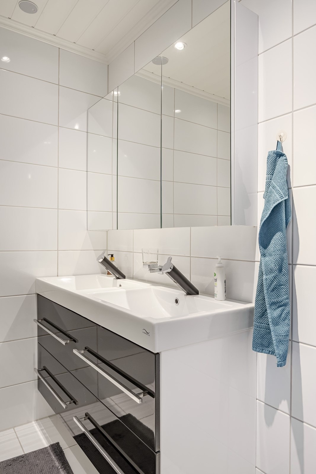 Badet har moderne baderomsinnredning med dobbel servant og speilskap for praktisk oppbevaring. Galleribilde