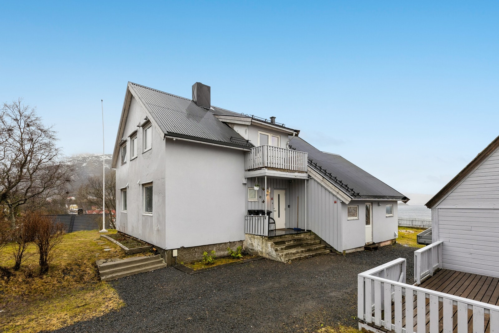 Her ser dere inngangspartiet med fin gressplen rundt boligen. Galleribilde