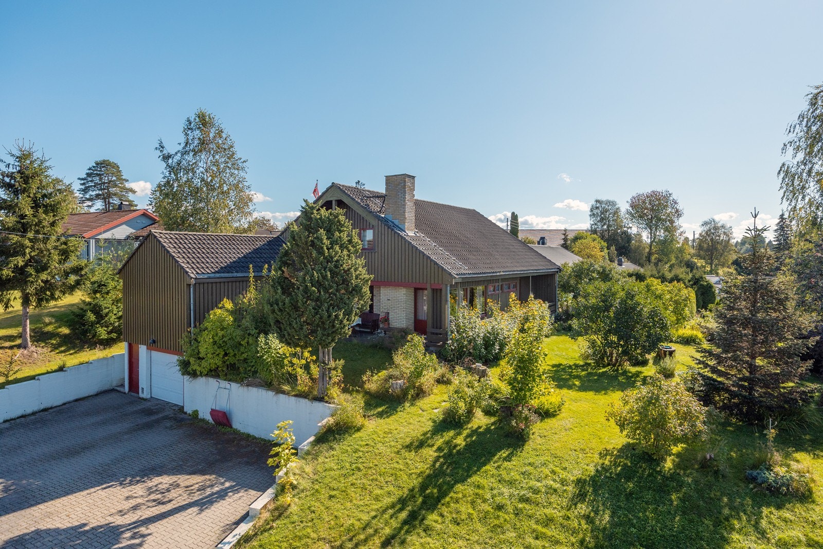 Den store tomten er frodig med gode plenarealer og steinlagt gårdsplass. Galleribilde