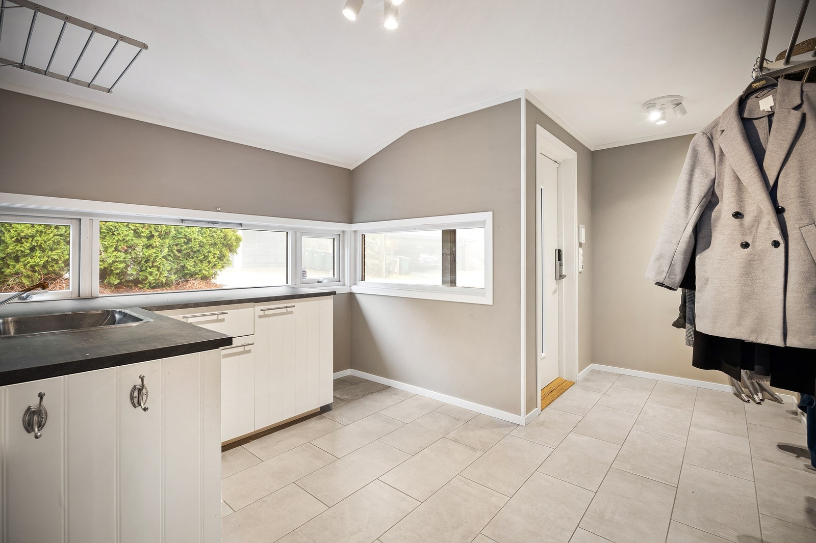 Den ene entréen har satt inn en profilert kjøkkeninnredning med oppvaskkum Galleribilde