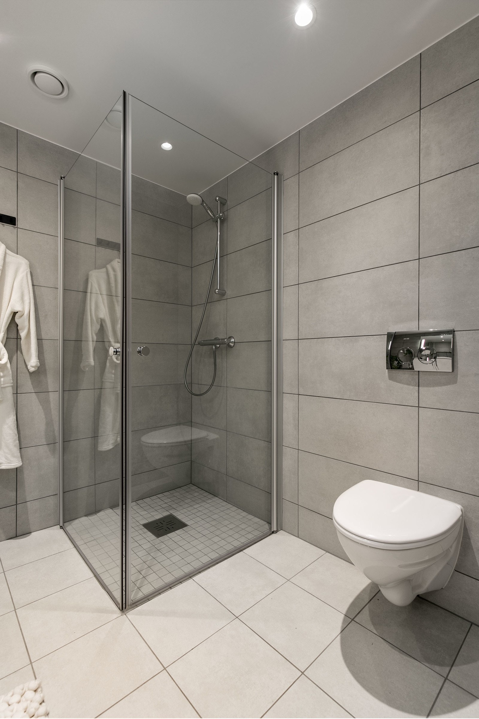 Badet har vegghengt toalett med innbygget sisterne, servant med skapinnredning samt speil med belysning. Galleribilde