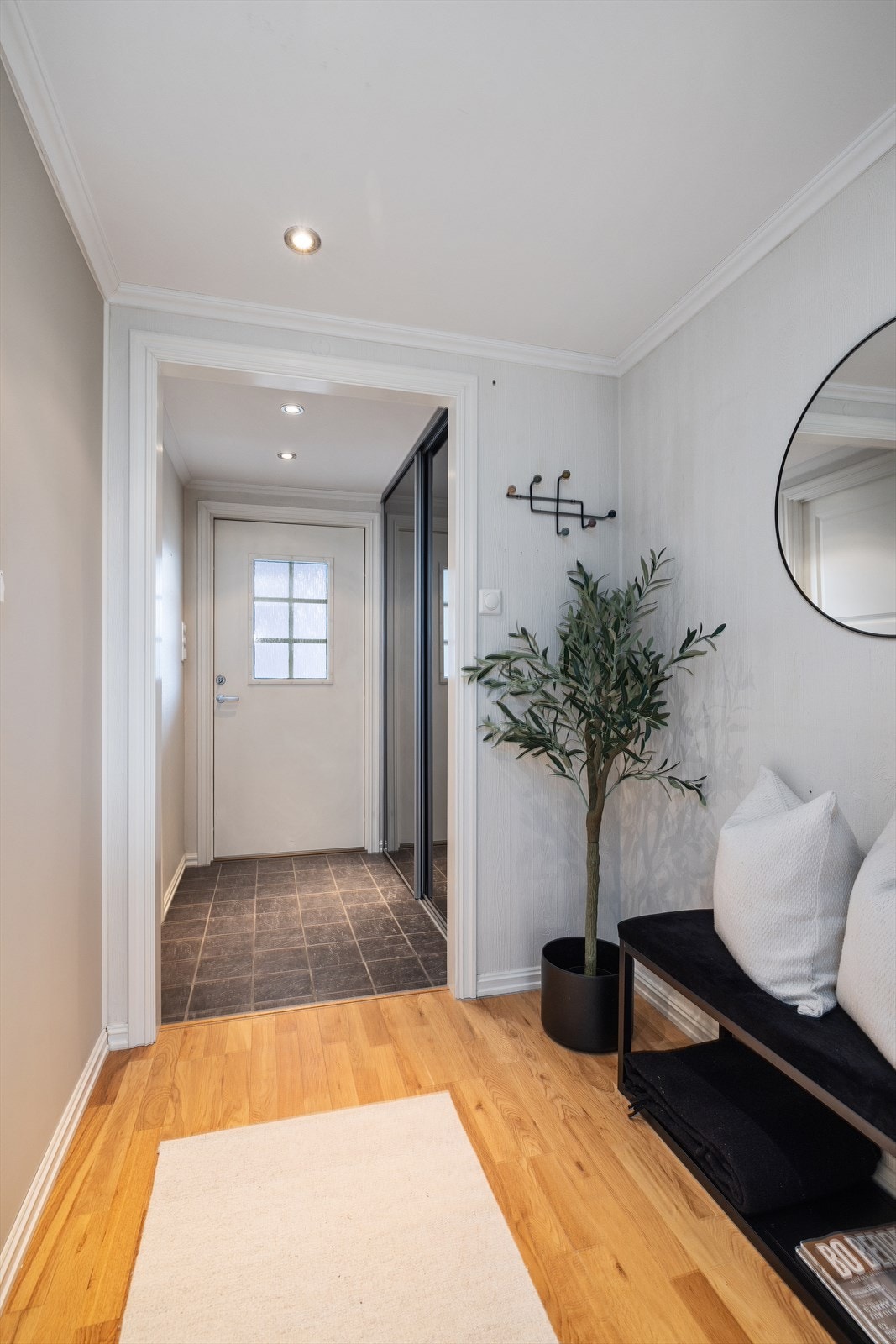 Fra entréen ledes du videre inn i boligens oppholdsrom, med en fin overgang fra flis til parkett. Galleribilde