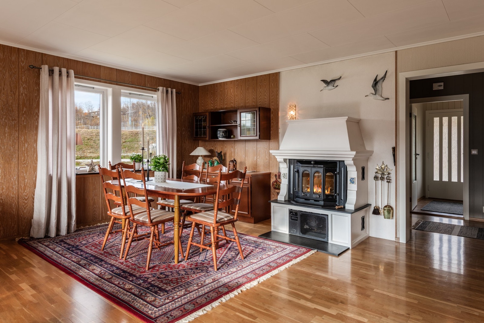 Koselig spisegruppe i stuen der peisen skaper ekstra hygge og varme Galleribilde