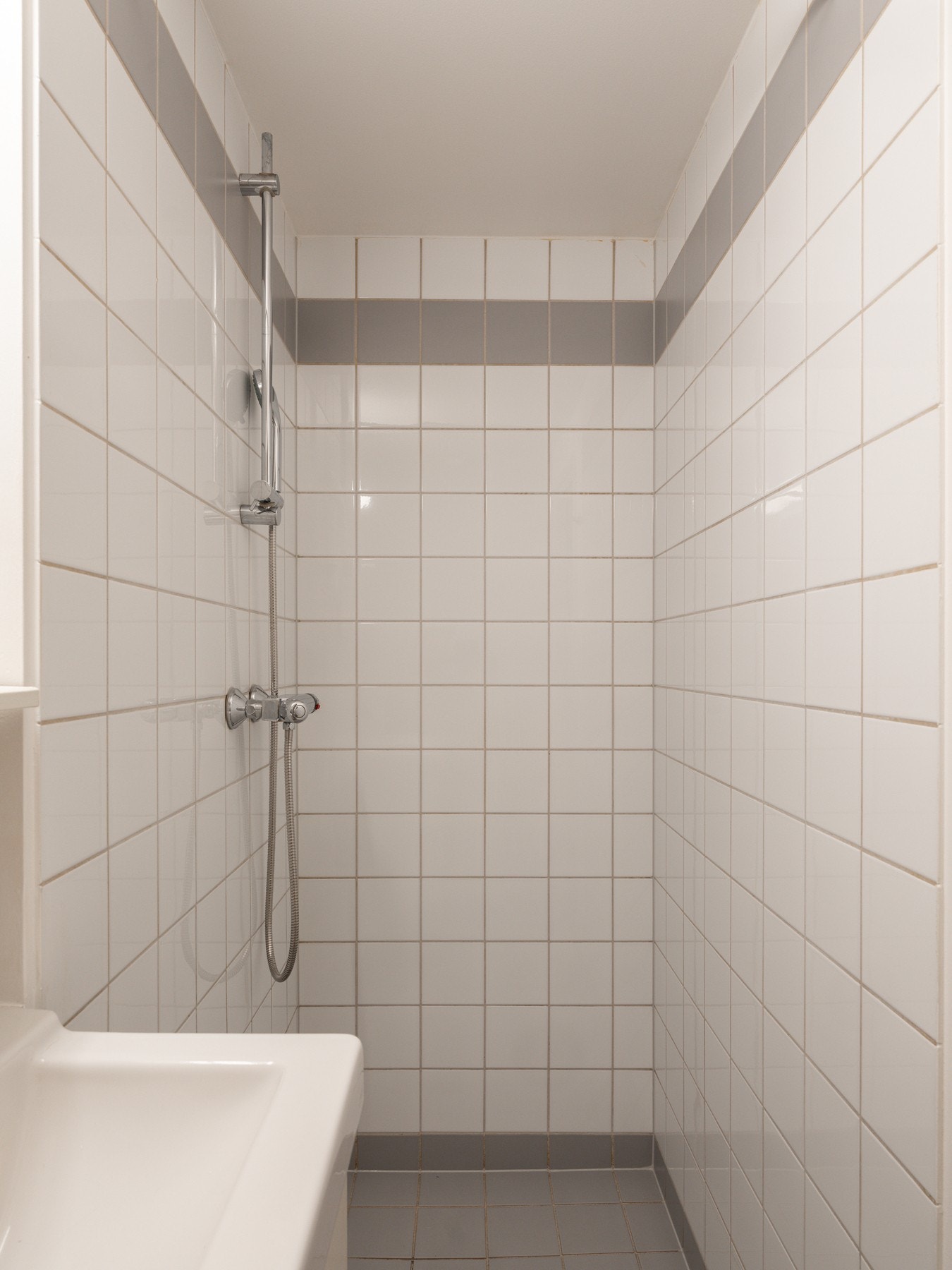 Badet inneholder servant med underskap, speil, dusjhjørne og toalett. Galleribilde