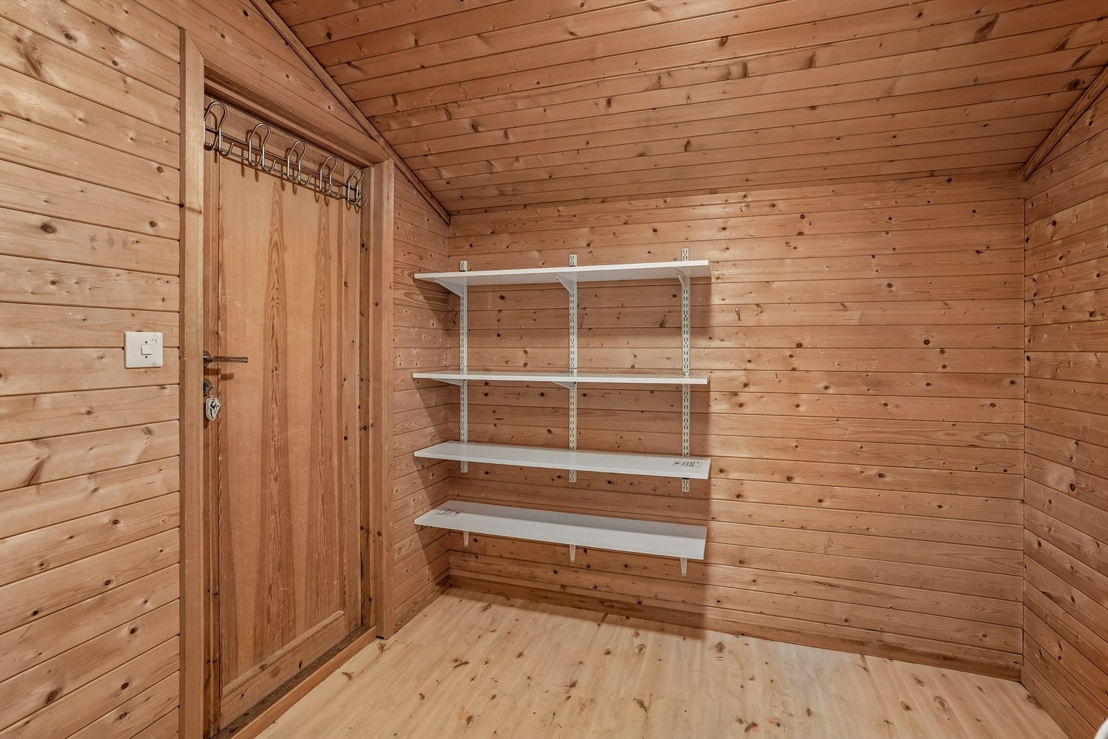 Praktisk innvendig bod med trepanel på veggane og god lagringsplass. Det er også dør ut herfrå. Galleribilde