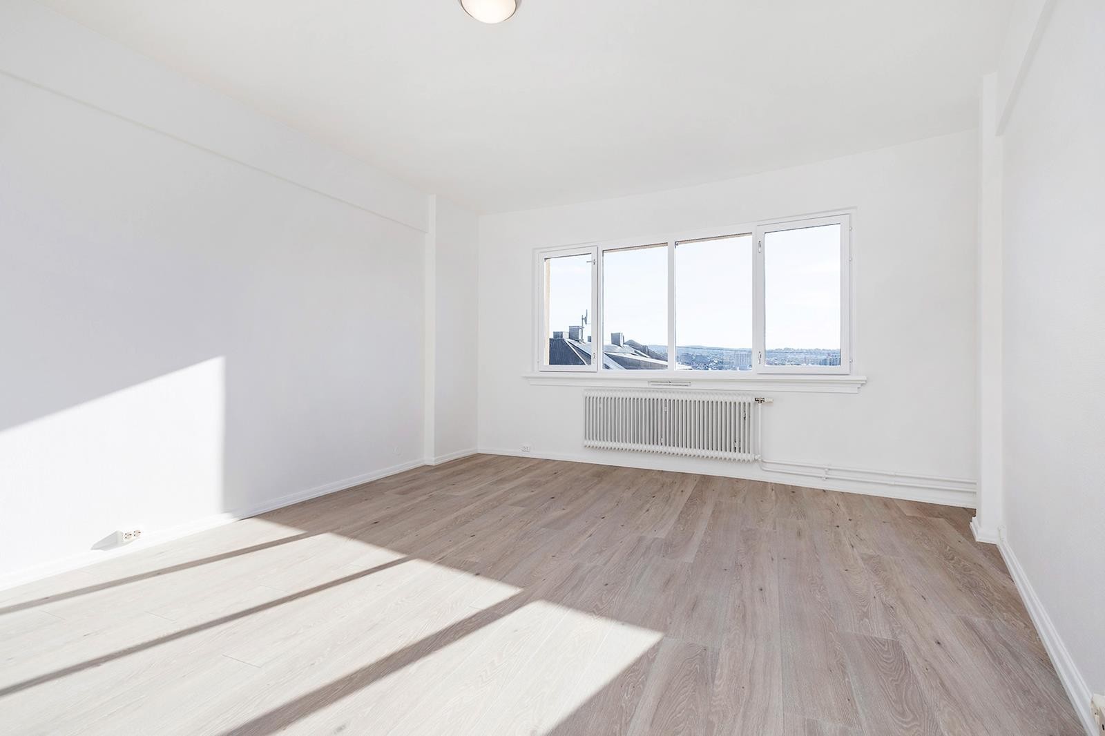 Stor oppholdsroms med plass til stor seng, sofa, spisestue og tv-benk. Galleribilde
