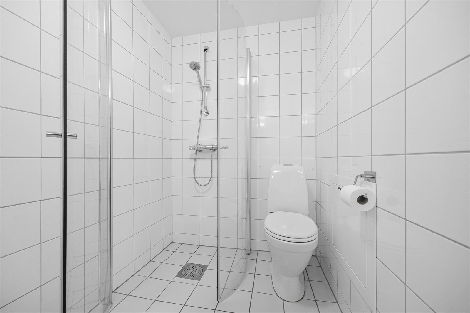 Videre er toalettet gulvmontert, dusjhjørnet har innfellbare glassdører og det er opplegg for vaskemaskin. Galleribilde