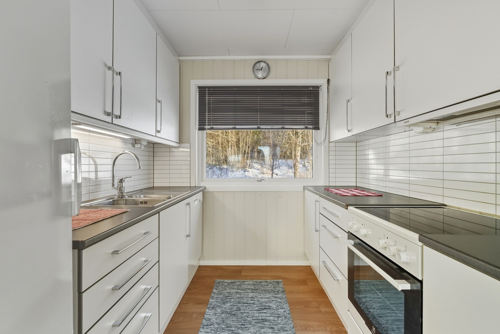 Kjøkkenet har hvite slette fronter og laminat benkeplate. Galleribilde