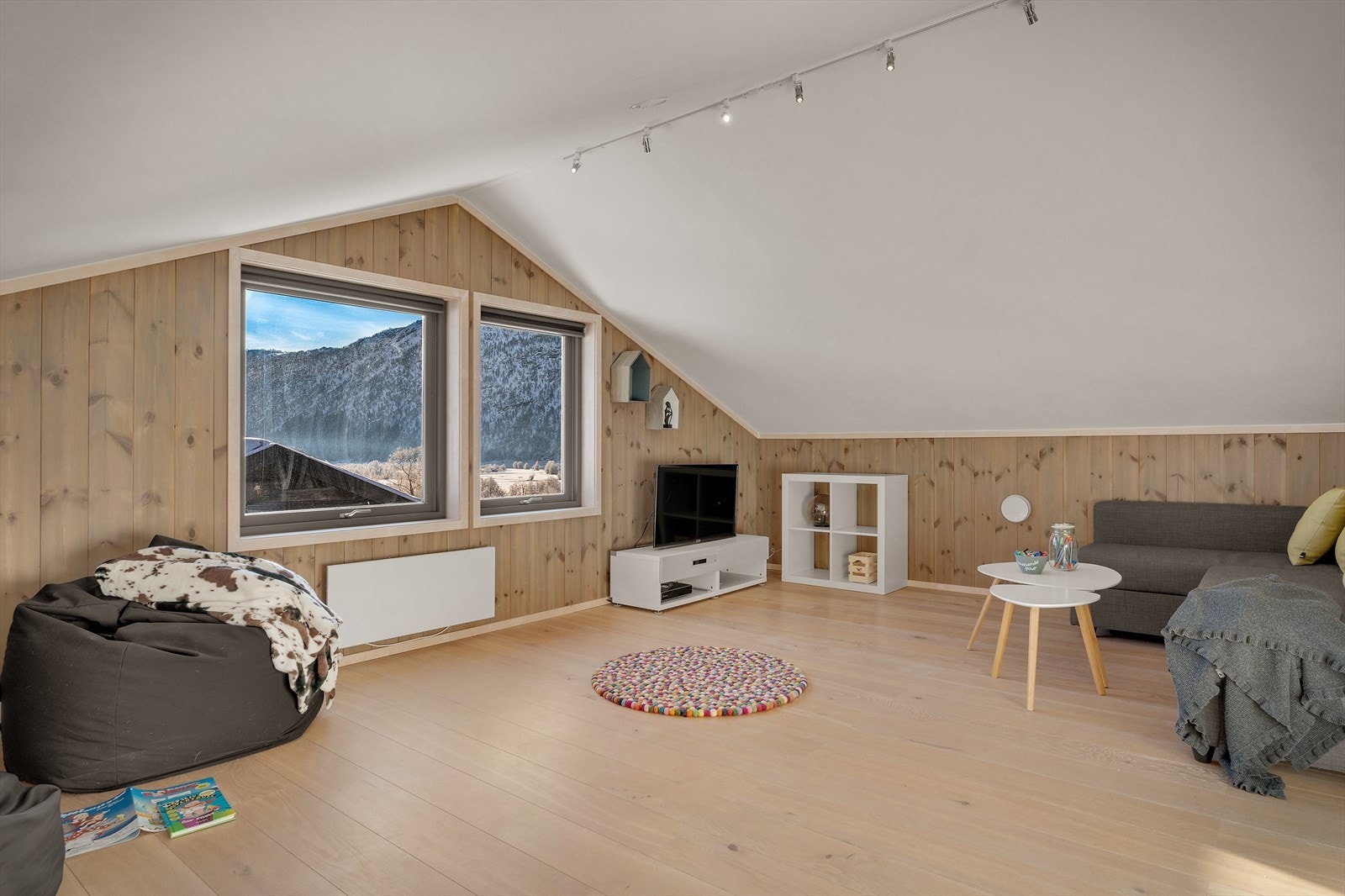 Rommet har plass til en hyggelig sofakrok og annet ønskelig møblement. Det er store vindusfelt som slipper inn behagelige mengder naturlig lys og ikke minst herlig utsikt Galleribilde