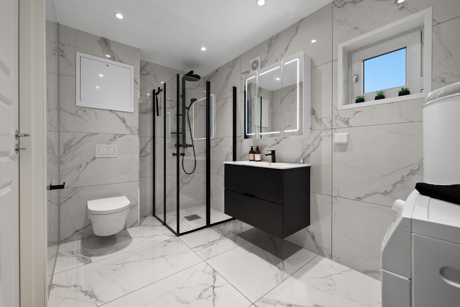 Badet i første etasje er innredet med store fliser på vegger og gulv, som gir et eksklusivt preg og er samtidig lett å vedlikeholde. Galleribilde