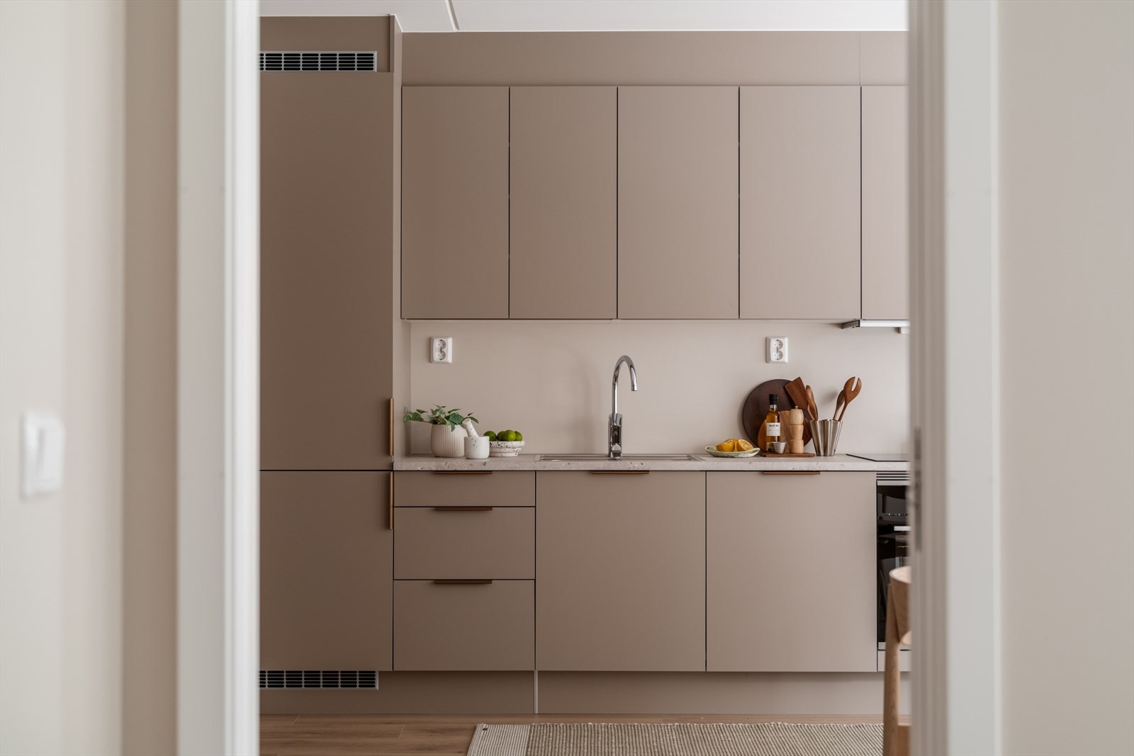 Moderne kjøkken med elegant, lys innredning som gir en åpen og innbydende atmosfære. Galleribilde