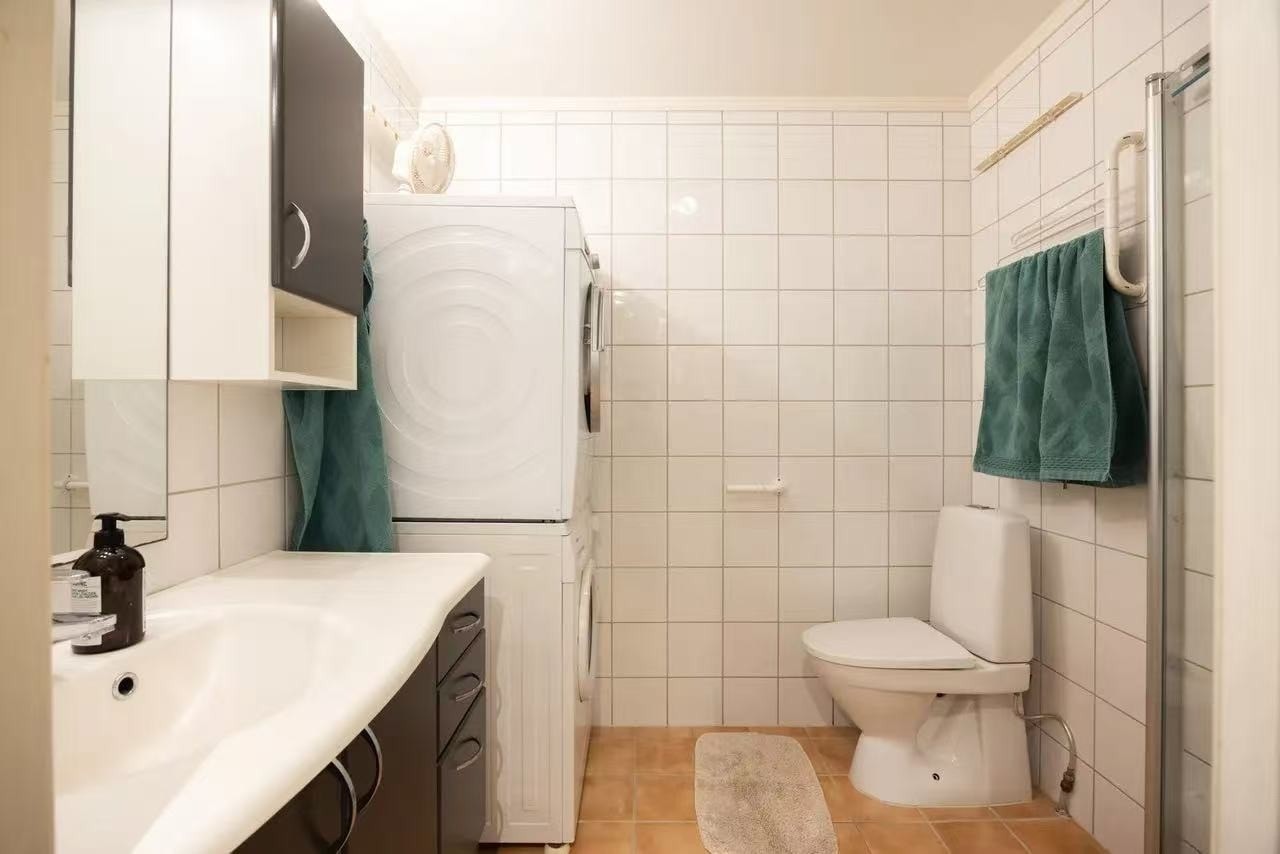 bad med dusj, toilet, vaskemaskin og tørketrommel Galleribilde