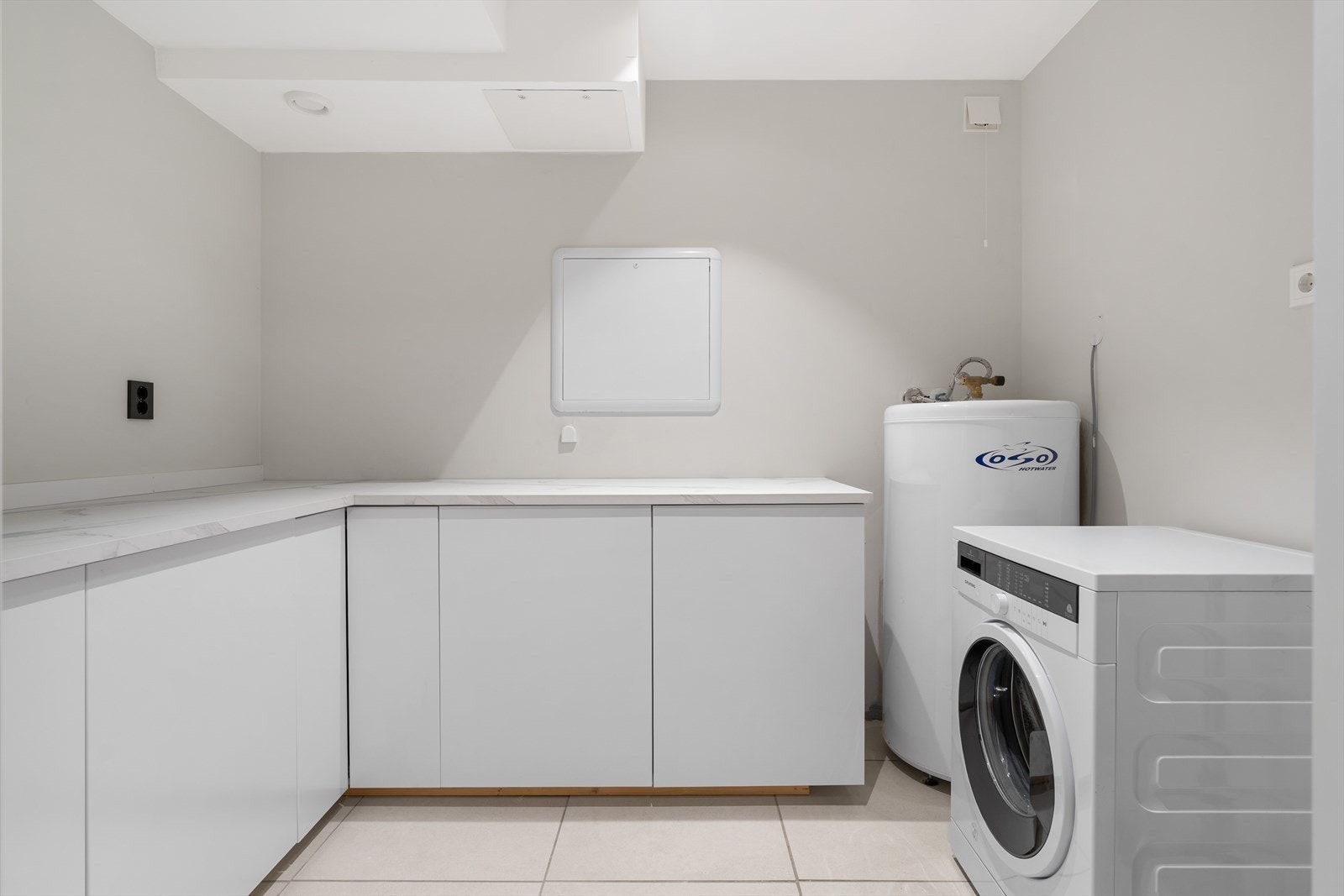 Vegg-i-vegg med badet har man tilgang til et nyrenovert og praktisk vaskerom på ca. 6 m². Galleribilde
