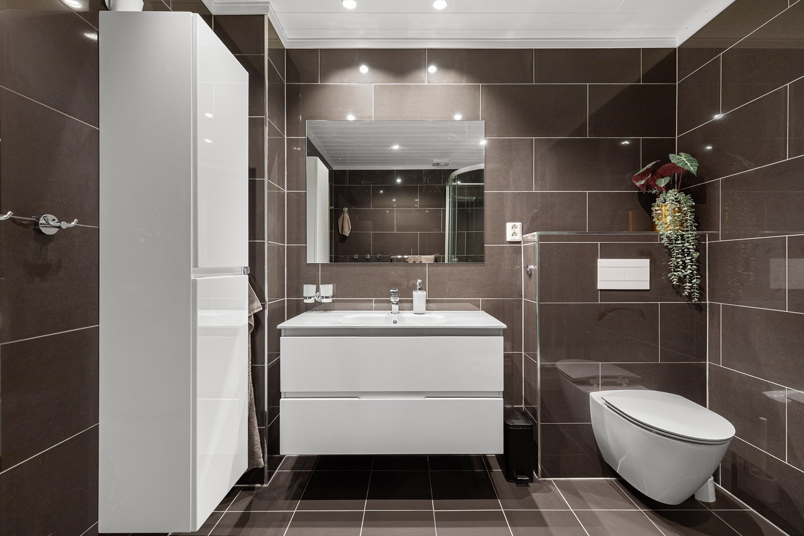 Badet er utstyrt med servant med baderomsinnredning, dusjkabinett og toalett. Galleribilde