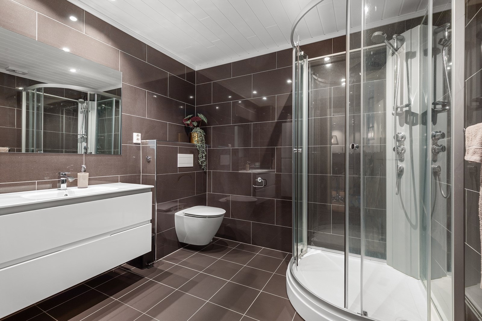 Badet har panel i himling, flislagt vegger og flislagt gulv. Galleribilde