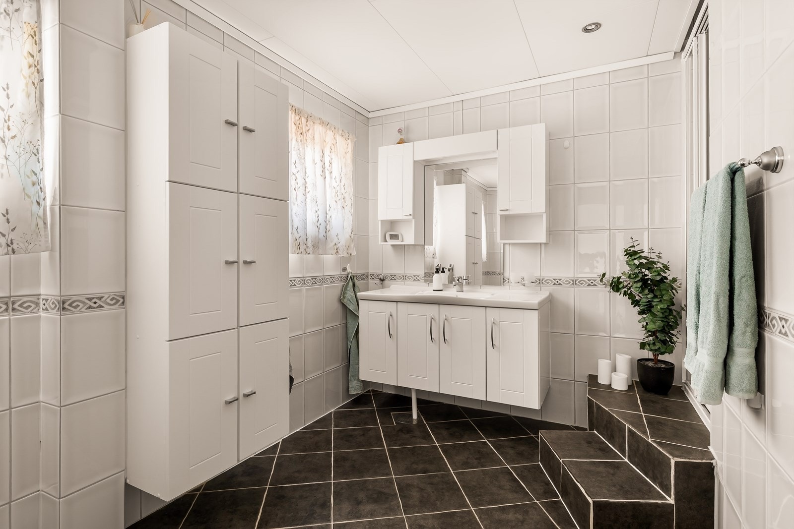 Rommet har en praktisk dusjnisje, servantskap med god oppbevaring og et vindu som gir naturlig lys og lufting. Galleribilde