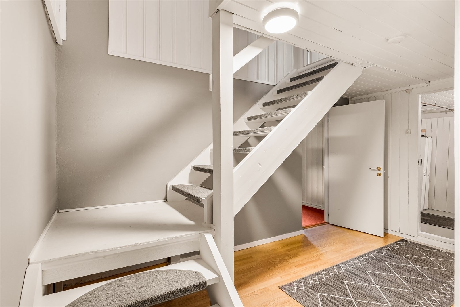 Den malte tretrappen forbinder alle tre etasjene i boligen. Galleribilde