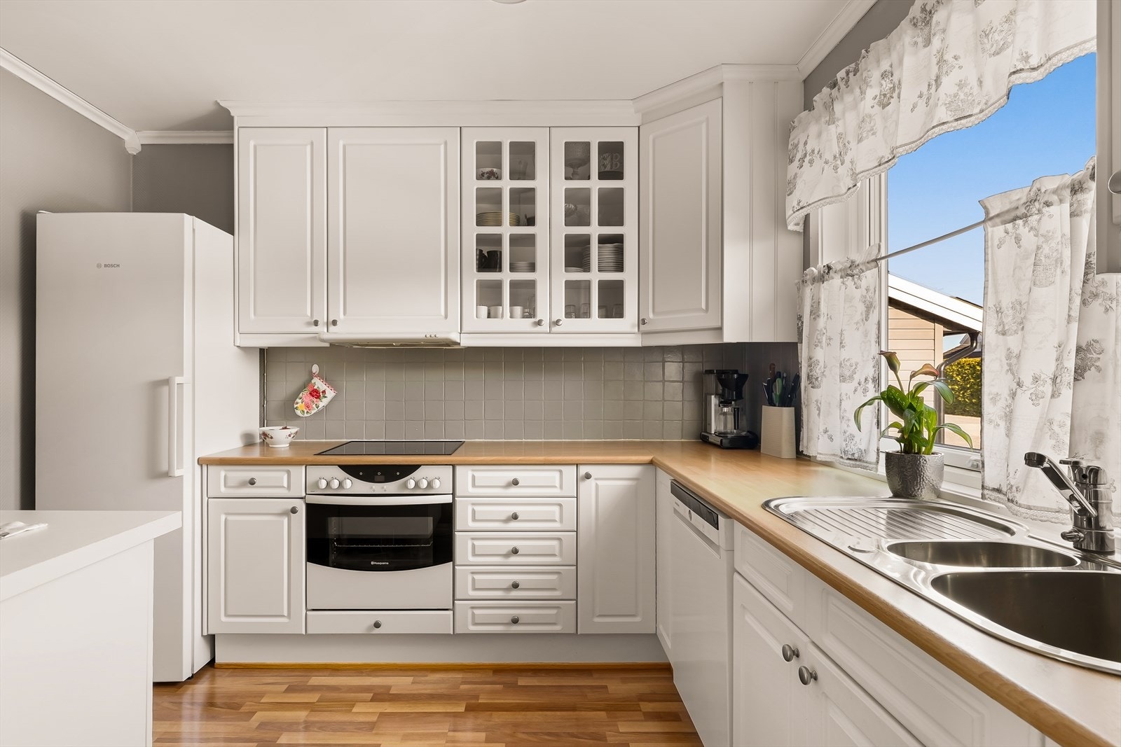 En praktisk skyveglassdør skiller kjøkkenet fra gangen, og gir en fleksibel overgang mellom rommene. Galleribilde