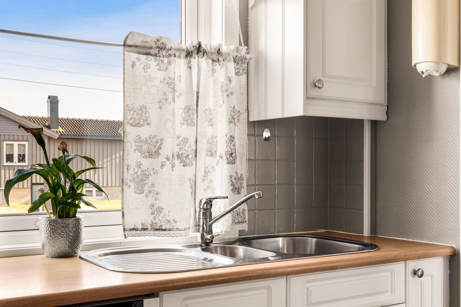 Benkeplaten i laminat gir rikelig med arbeidsflate, og oppvaskkummen har to praktiske kummer. Galleribilde