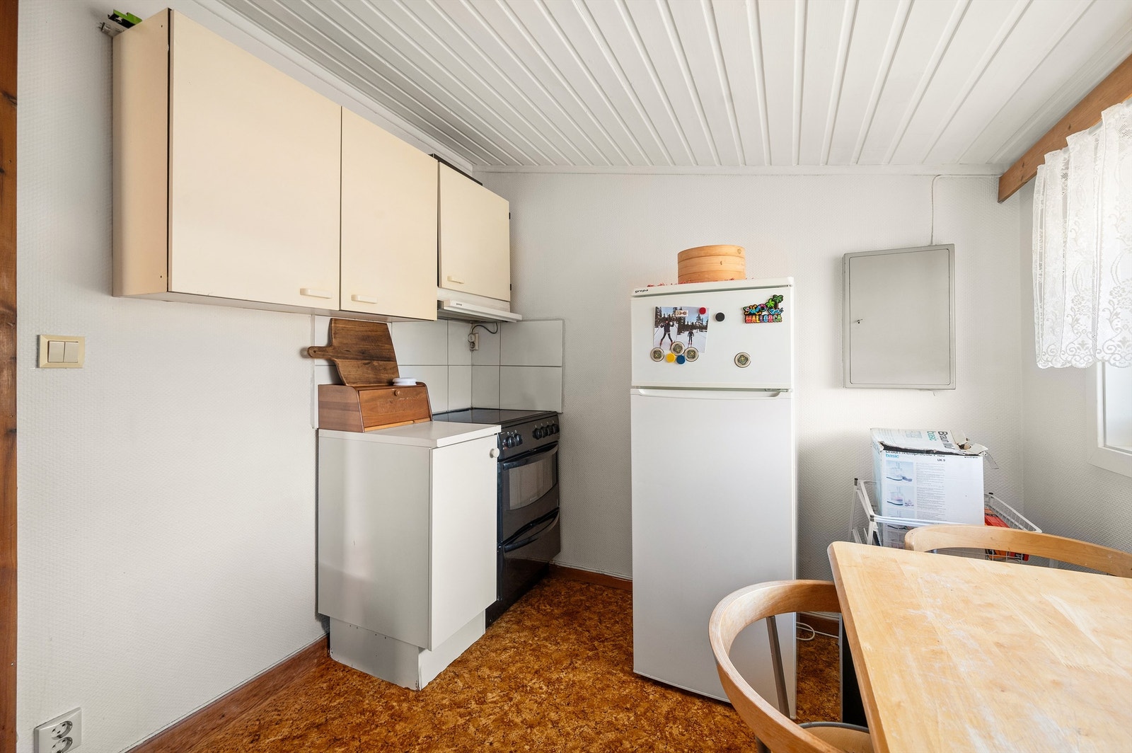 Kjøkkeninnredning med profilerte fronter og kullfilterventilator over kokeplassen. Galleribilde