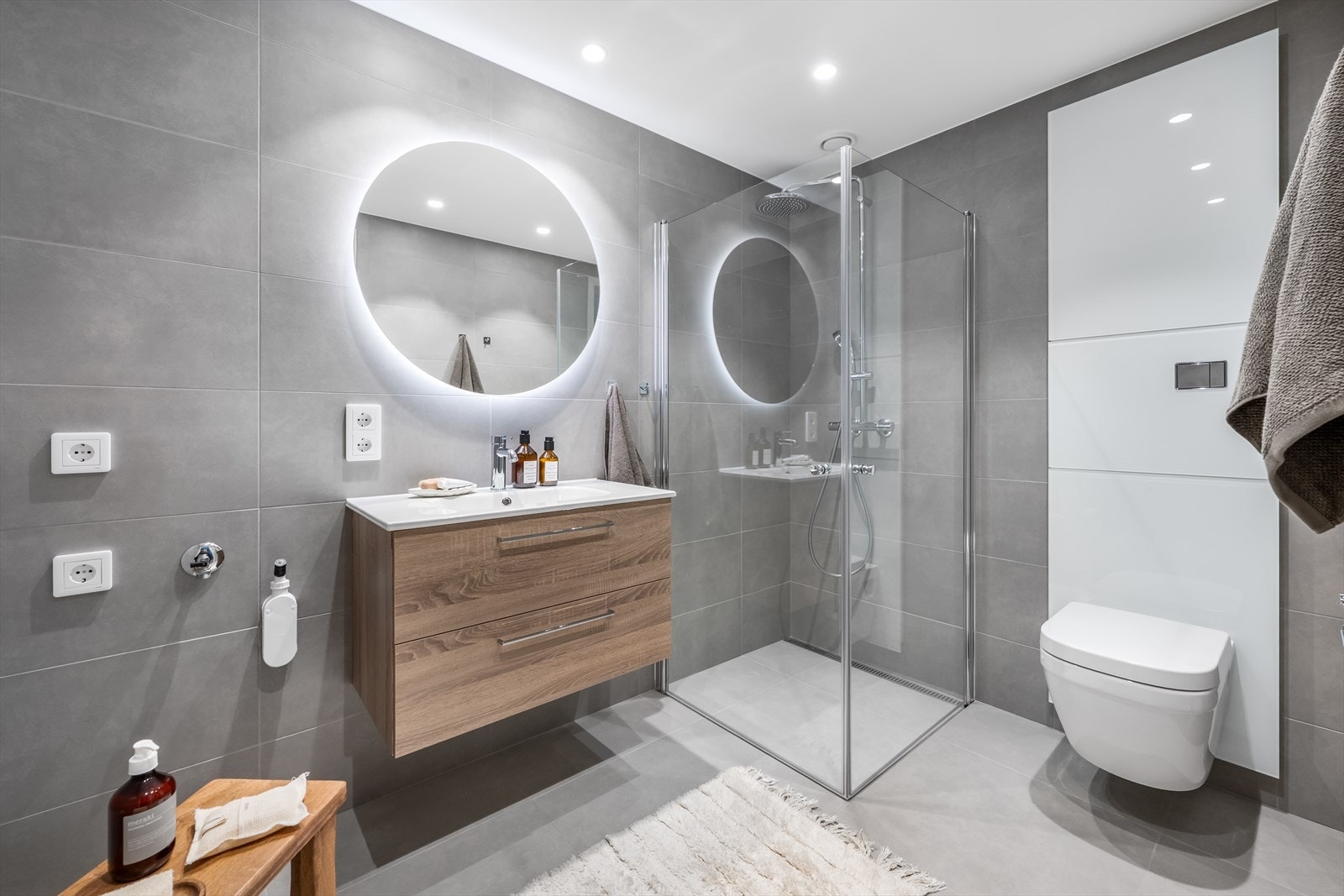 Badet byr på dusj med innfellbare glassdører. servant med underskuffer, vegghengt toalett og opplegg for vaskemaskin. Galleribilde