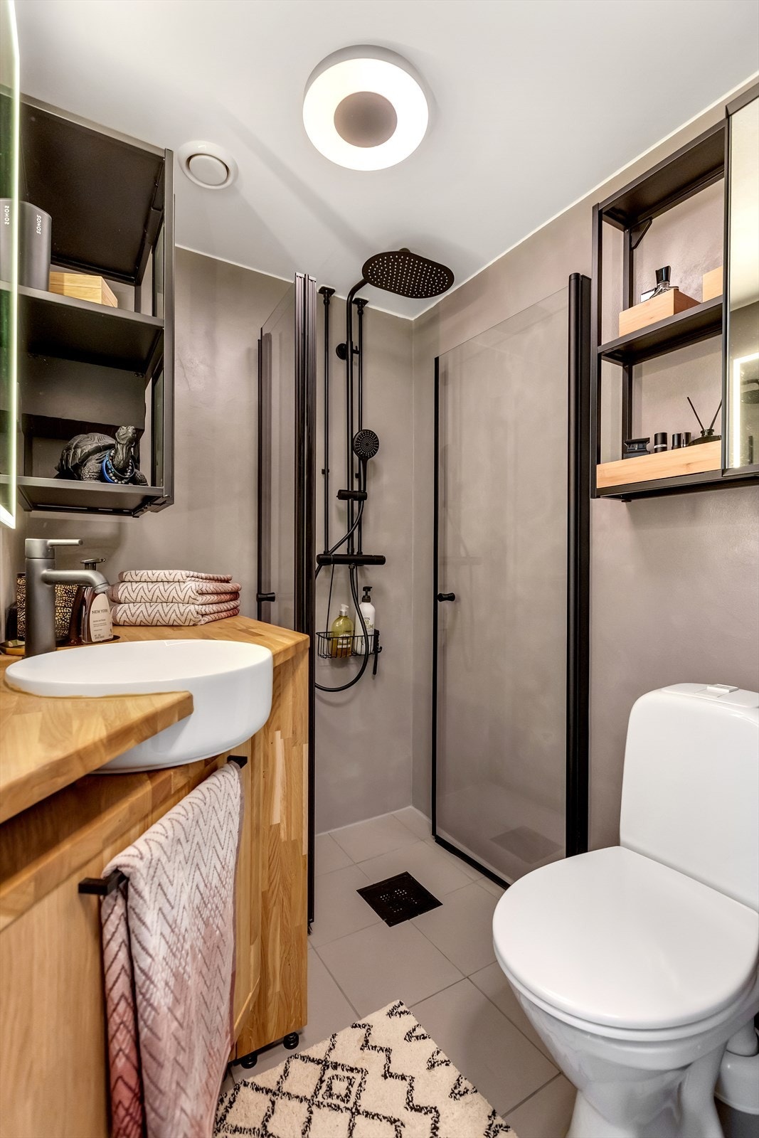 Pent flislagt bad med gulvvarme. Badet er utstyrt med dusjhjørne, servant med måltilpasset møbel, toalett og opplegg for vaskemaskin. Galleribilde
