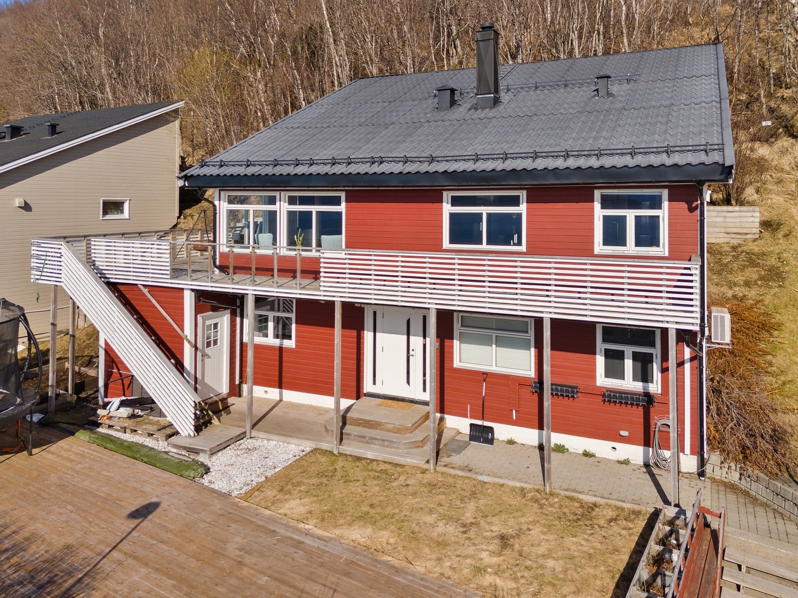 Terrasse foran hele boligen, samt trapp ned til mark. Galleribilde