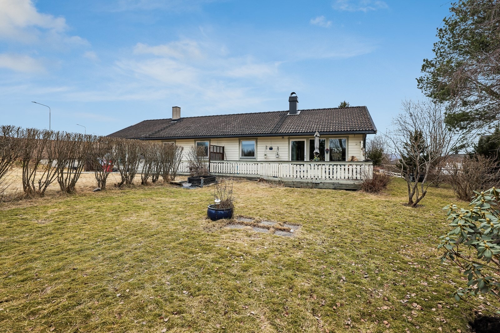 Eiendommen har en lettstelt, flat tomt opparbeidet med diverse busker og trær. Galleribilde