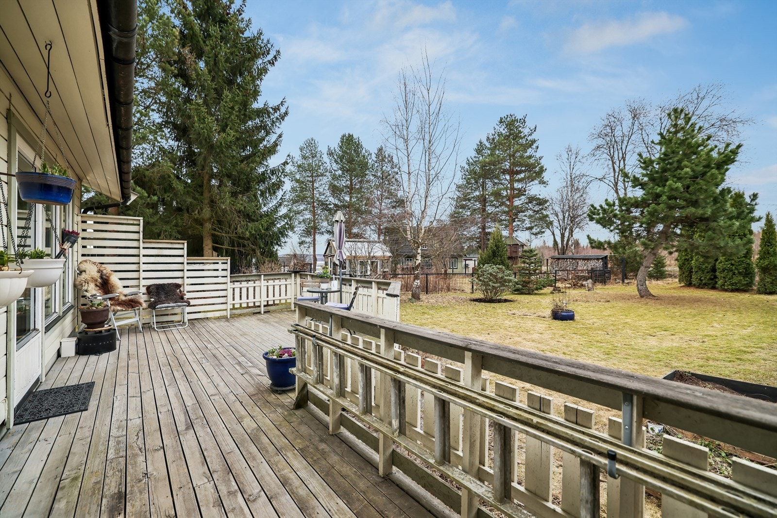 Terrassen har trerekkverk og gir en åpen overgang til hagen Galleribilde