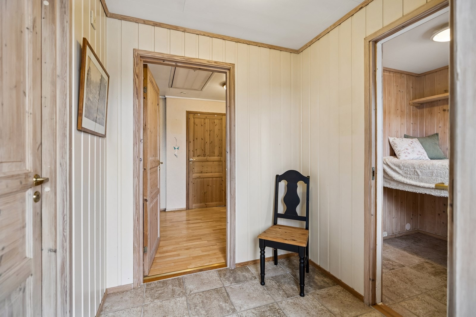 Entréen fordeler adkomsten til boligens rom. Veggene er kledd med trepanel og tapet. Galleribilde