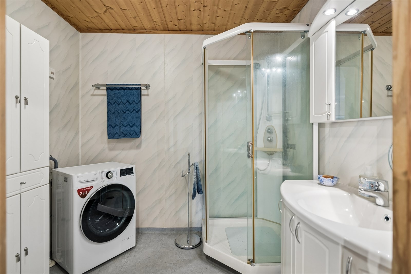 Badet er innredet med dusjkabinett, servantmøbel og har opplegg for vaskemaskin. Galleribilde