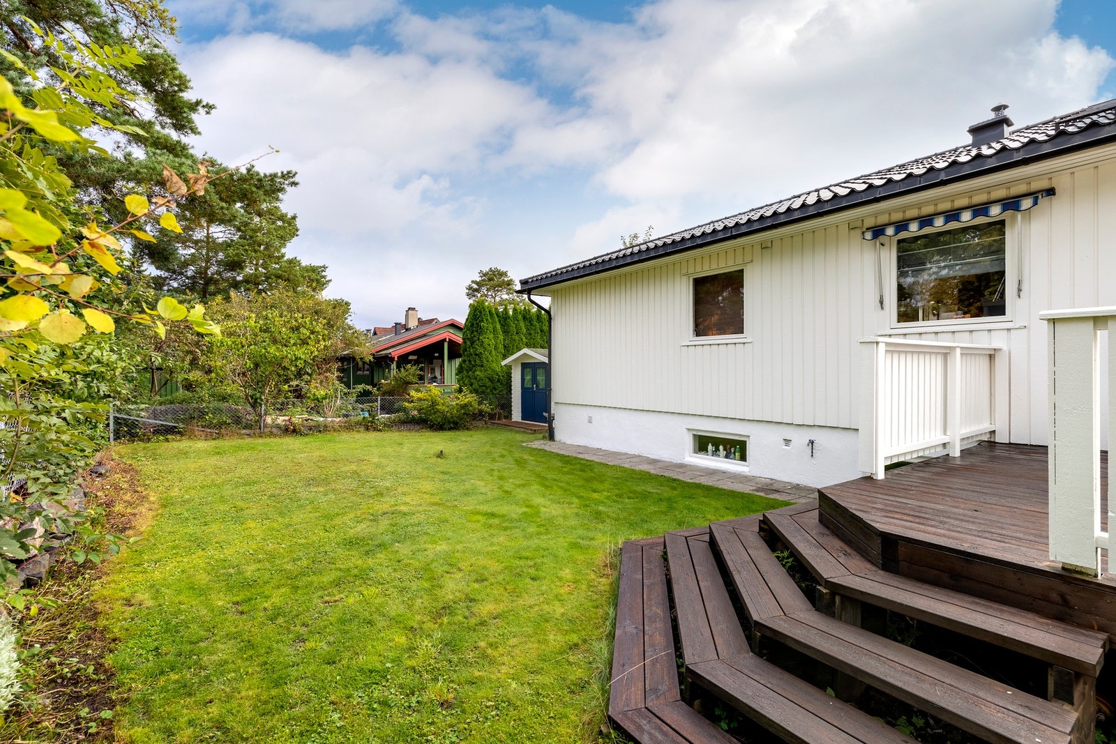 Fra terrassen leder en trapp ned til en nydelig hage. Hagen er opparbeidet over flere nivåer, med en fin kombinasjon av naturtomt, plen og busker. Galleribilde