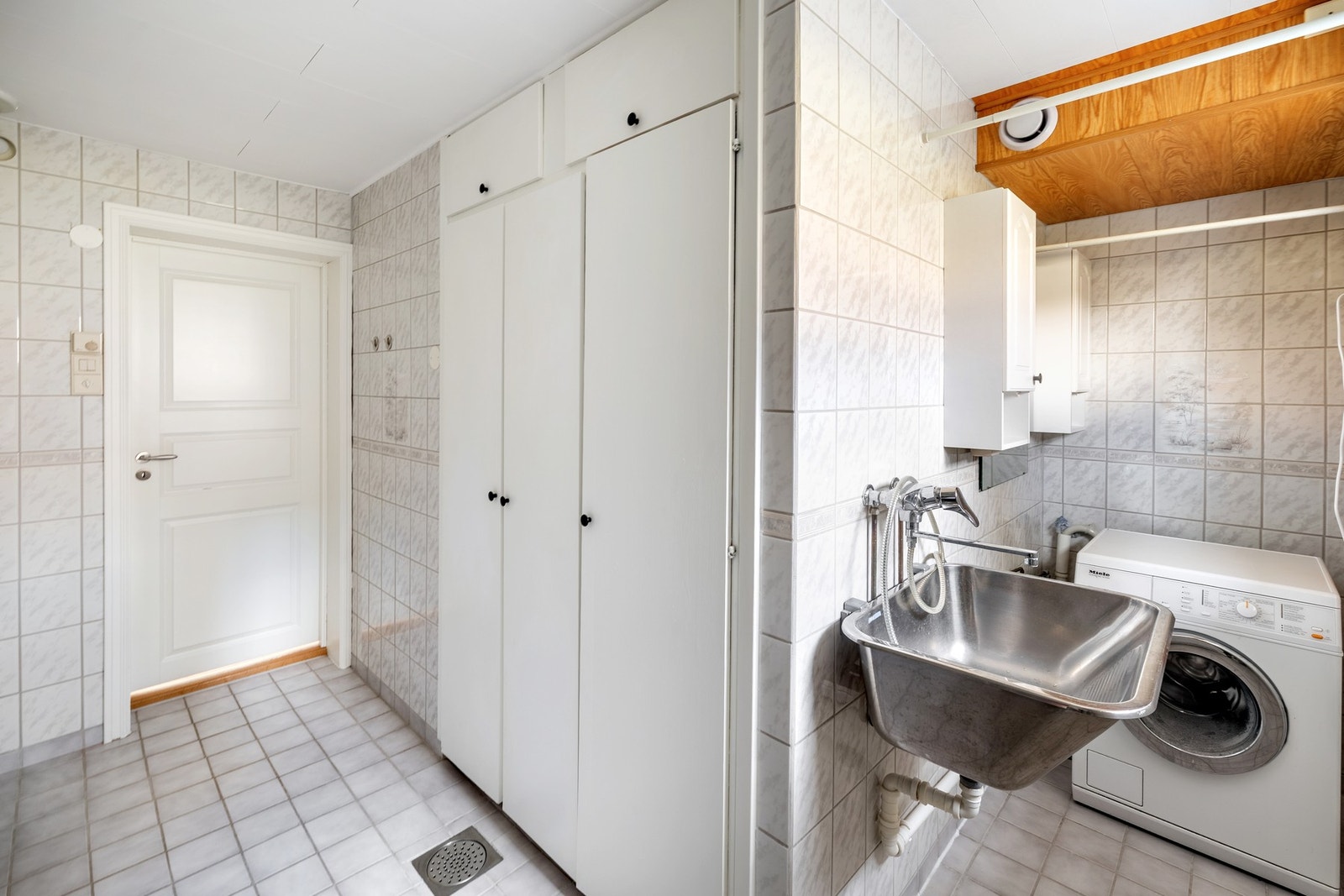 Vegg i vegg med badet i underetasjen ligger vaskerommet. Vaskerommet er både praktisk og godt utstyrt, perfekt for hverdagsbruk. Galleribilde