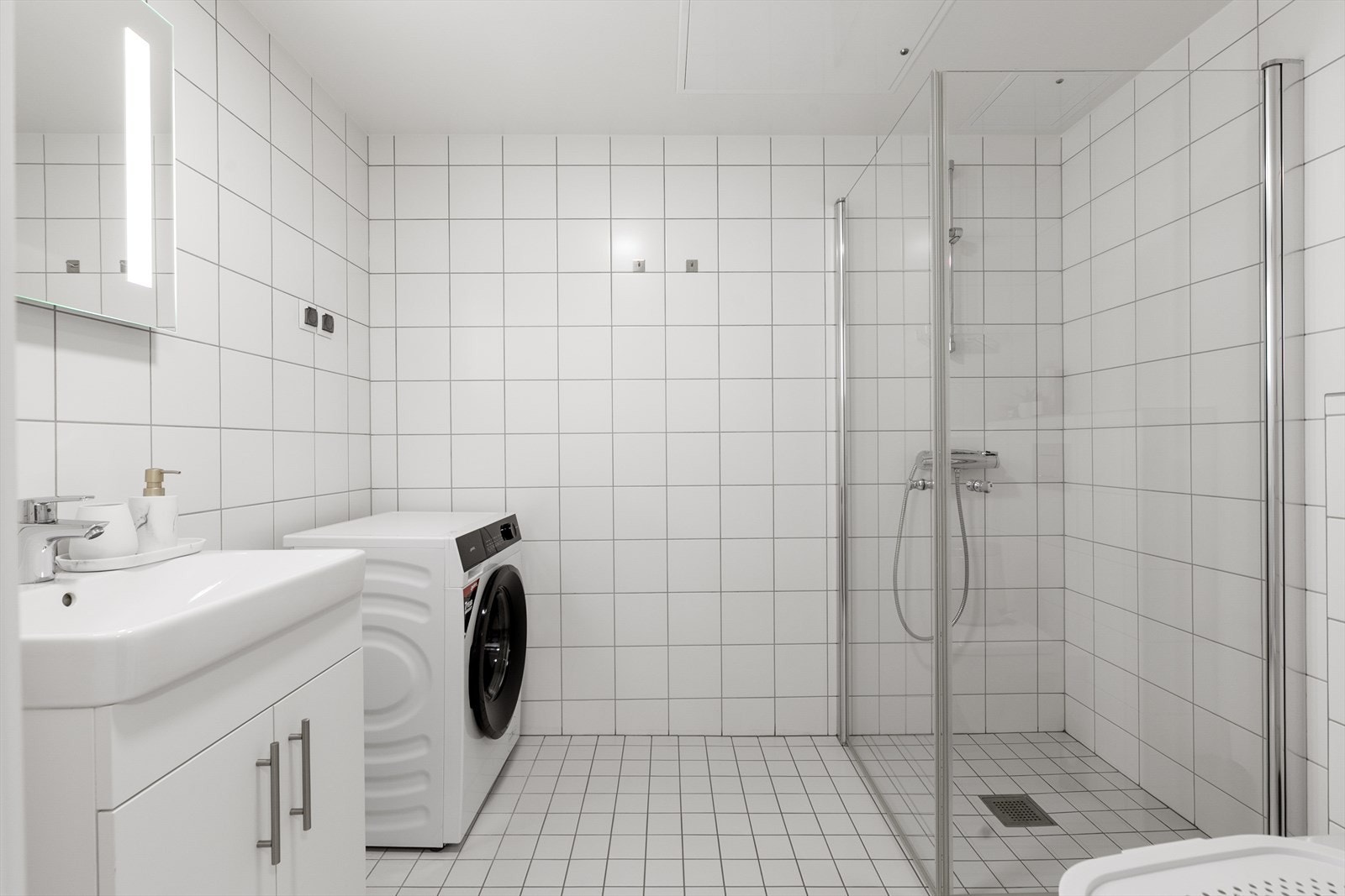 Badet har et vegghengt toalett og et dusjhjørne med inn- og utadslående dører i herdet glass. Galleribilde