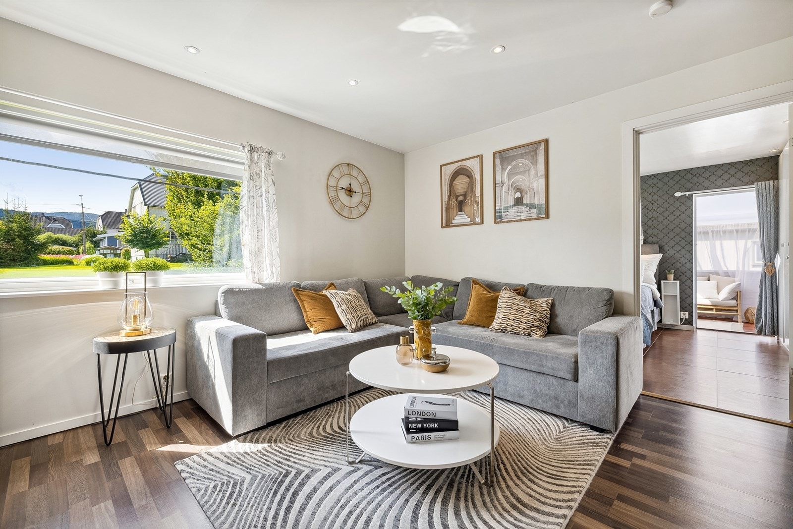 Lys og stilren stue med laminat på gulv og slette vegger malt i en lys fargetone. Galleribilde