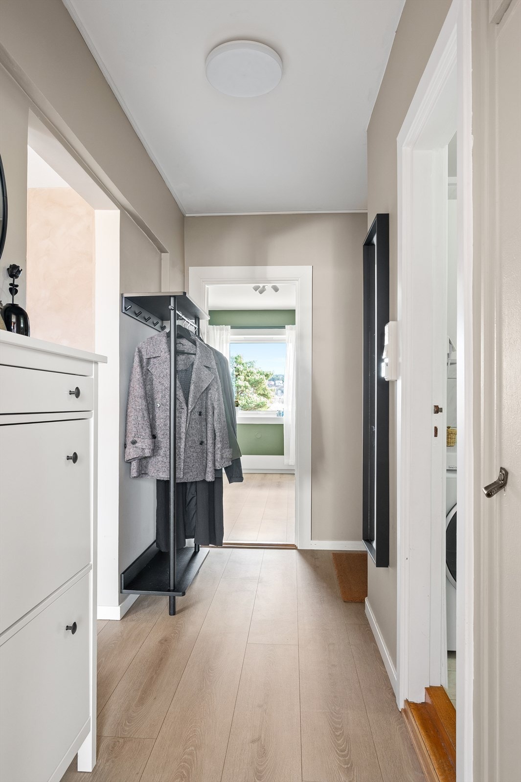 En lys entré ønsker velkommen og binder leilighetens rom sammen. De fleste innervegger ble malt i 2021. Galleribilde