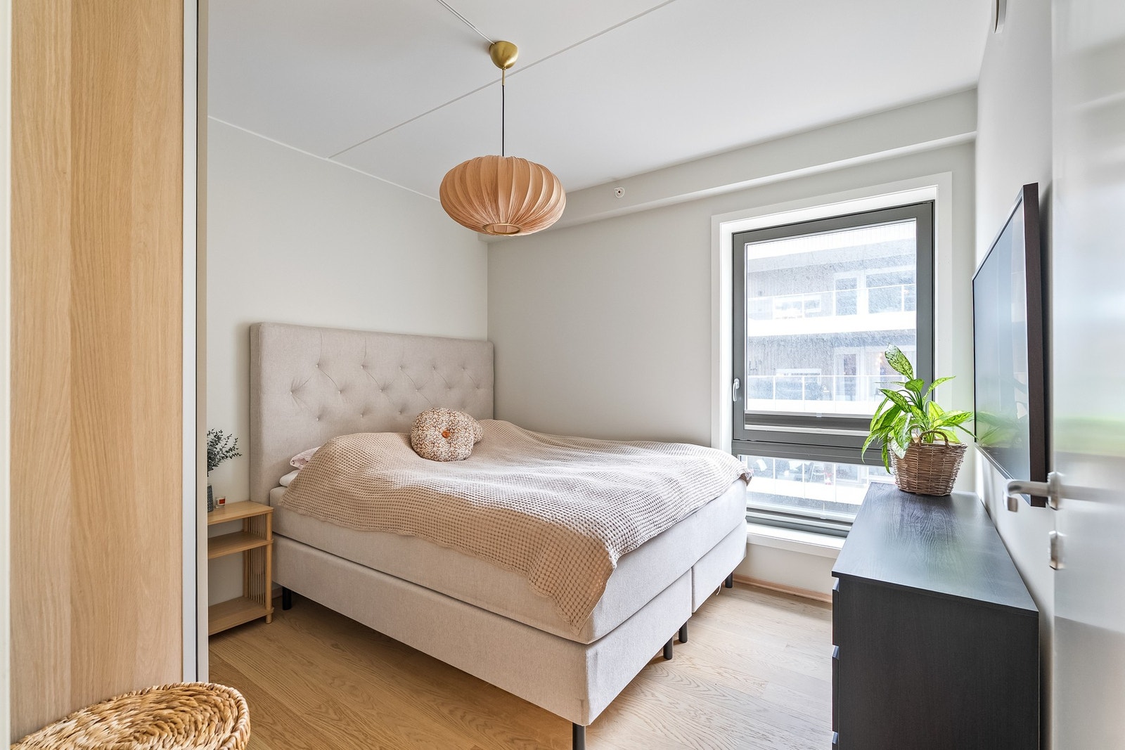 Hovedsoverommet fremstår som meget tiltalende med lysmalte slette veggflater, enstavs parkett på gulv og et stort vindu. Galleribilde