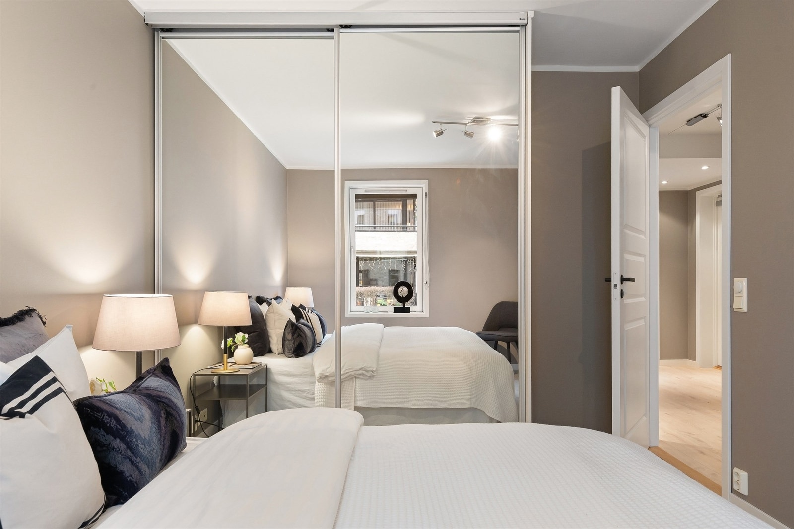 En stor skyvedørsgarderobe med speilfronter gir rikelig med oppbevaringsplass. Galleribilde
