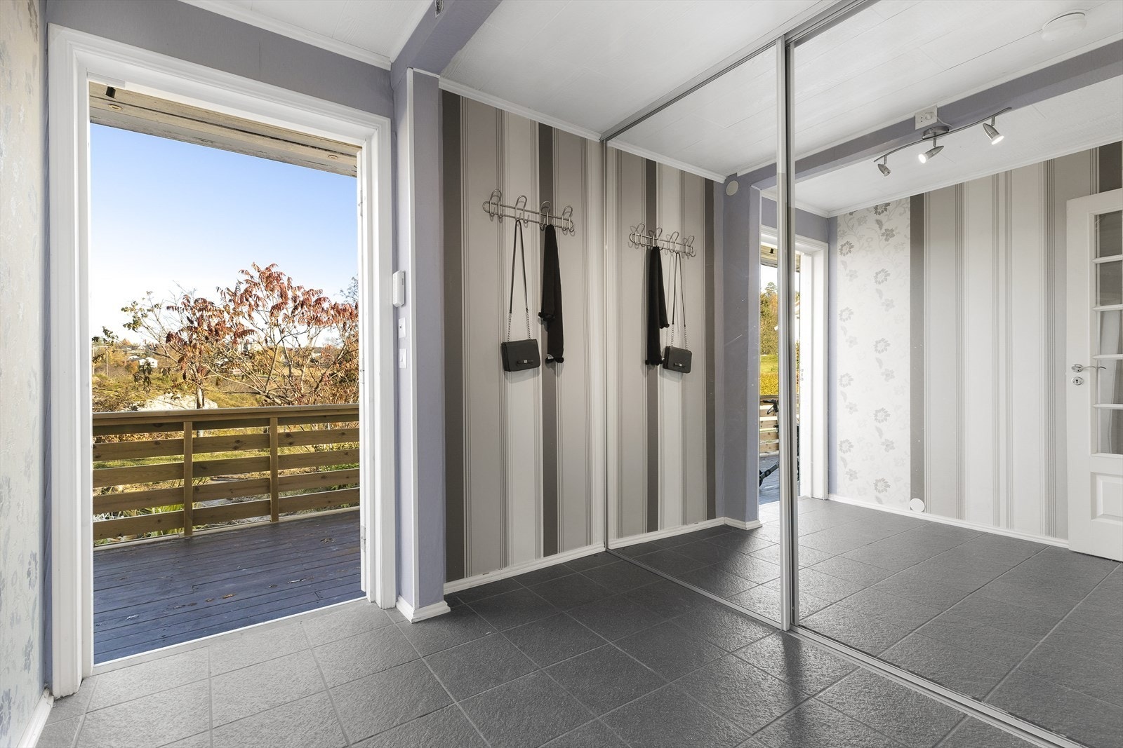 Velkommen inn! Entréen er innredet med skyvedørsgarderobe med speildører. Galleribilde