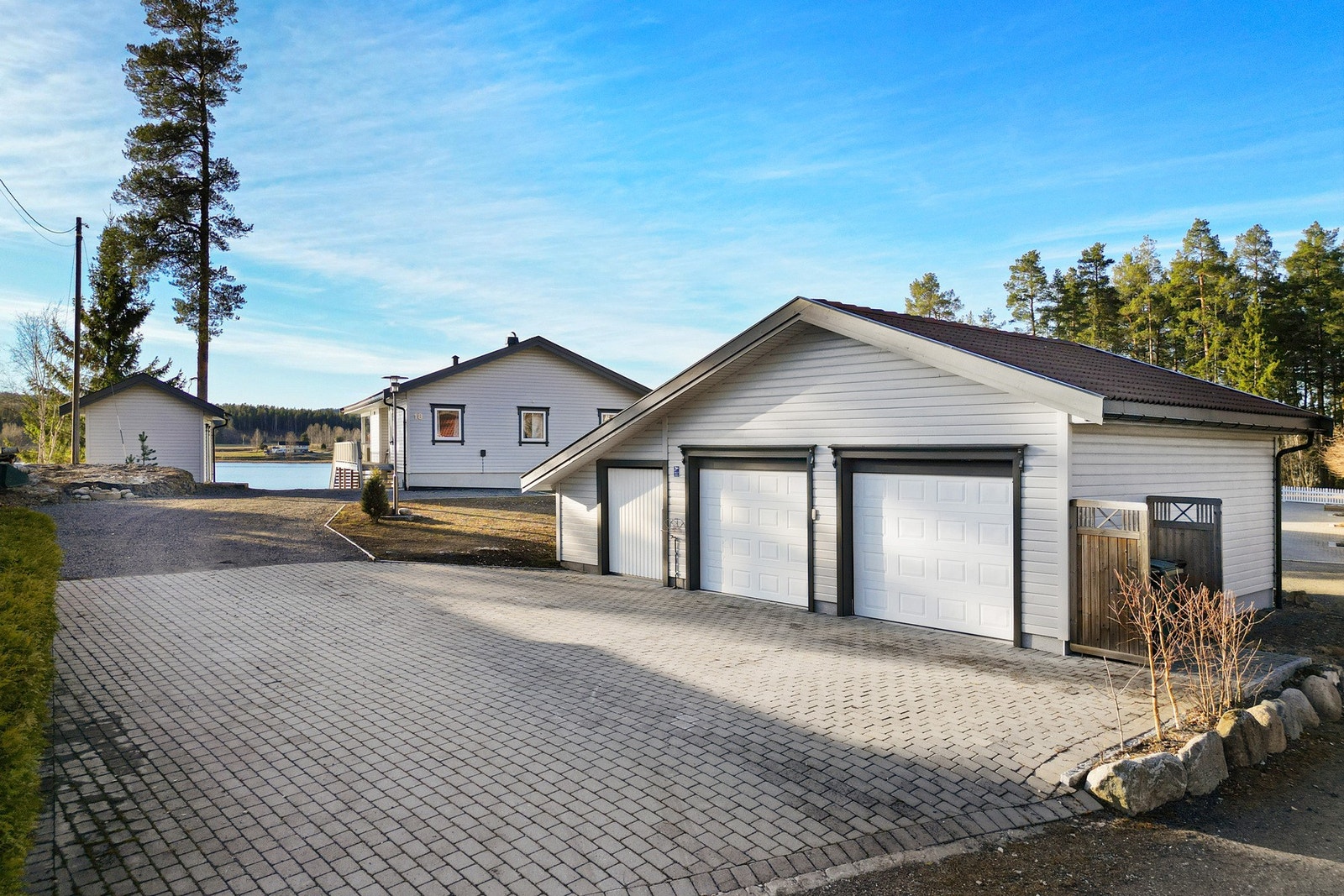 Stor dobbelt garasje. Brosteinsbelagt gårdsplass.
Kveldsstemning. Galleribilde