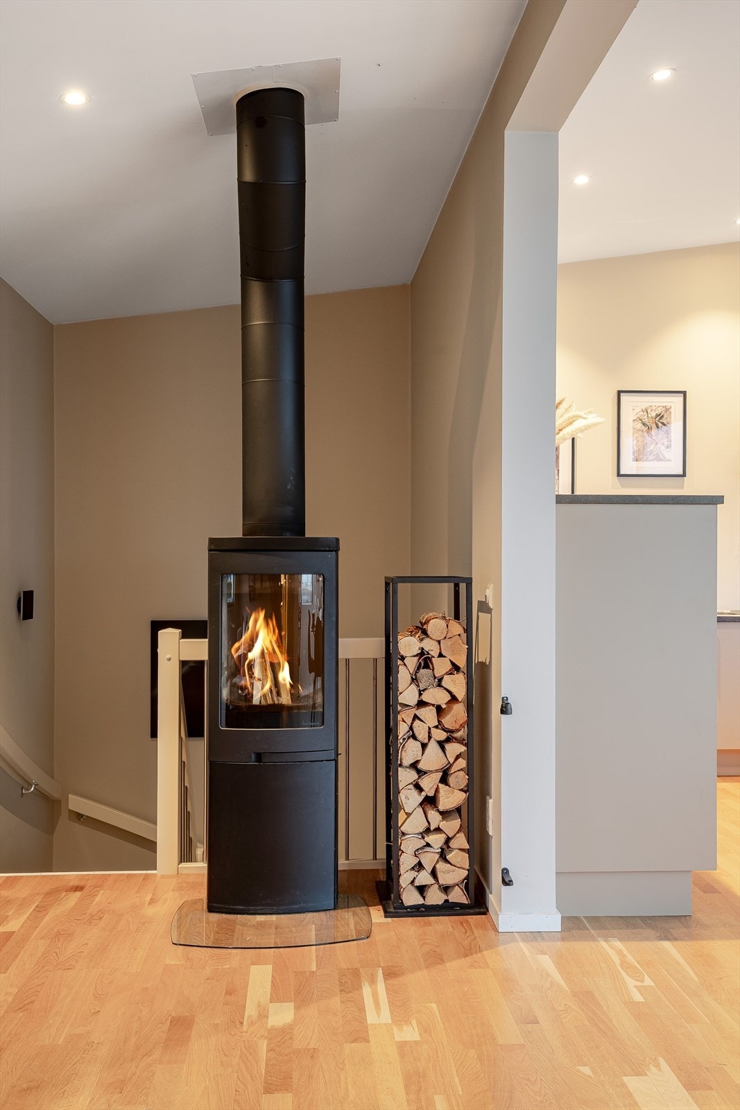 Som et fint midtpunkt i stuen har du en moderne vedovn som gir god varme, samt bidrar til ekstra hygge både fra sofakroken og spisebordet. I tillegg er det varmefolie i gulvene. Galleribilde