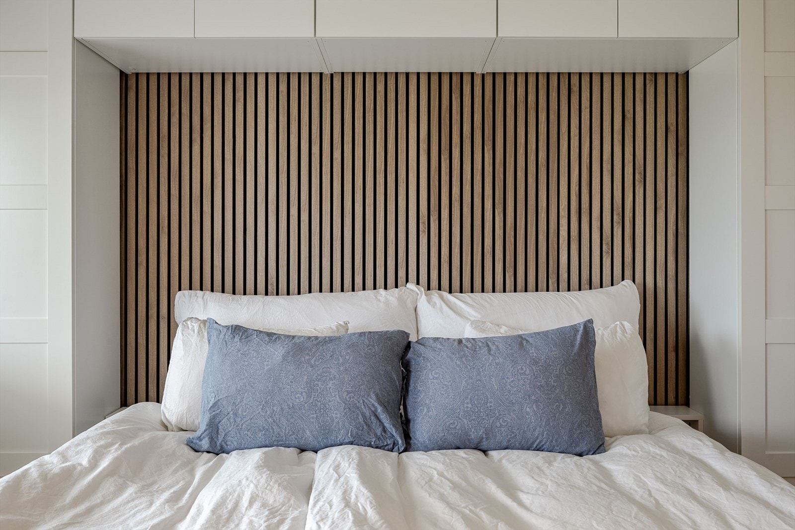 Veggen bak sengen er dekorert med tidsriktige trespiler. God oppbevaringsplass i garderobeløsning med skap på begge sider i tillegg til vegghengte skap over. Galleribilde