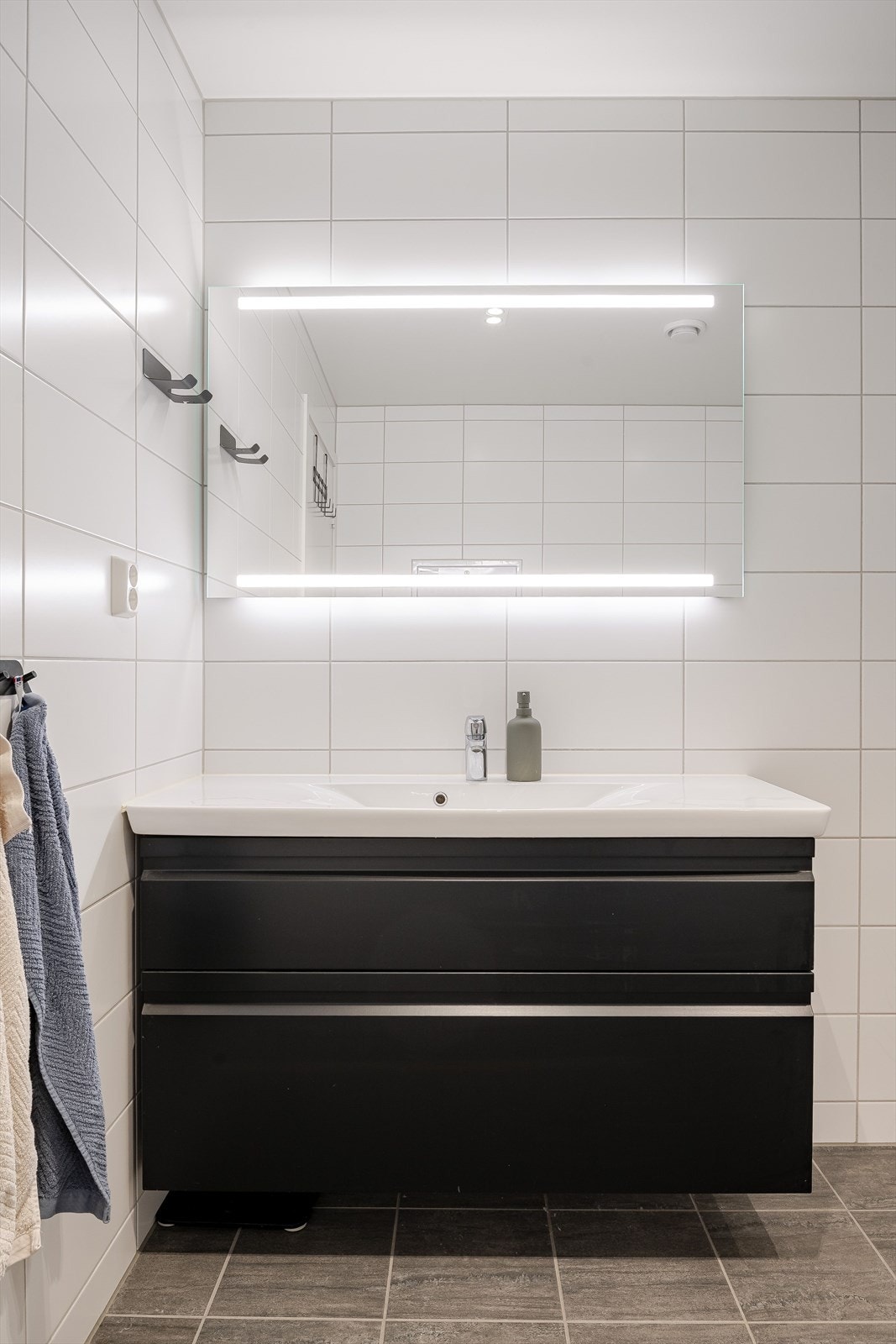 I tilknytning til soverommene i 1. etasje har du et stort, lyst og moderne baderom fra byggeåret 2019. Moderne baderomsinnredning med skuffer og heldekkende servant, speil med integrert belysning over. Galleribilde