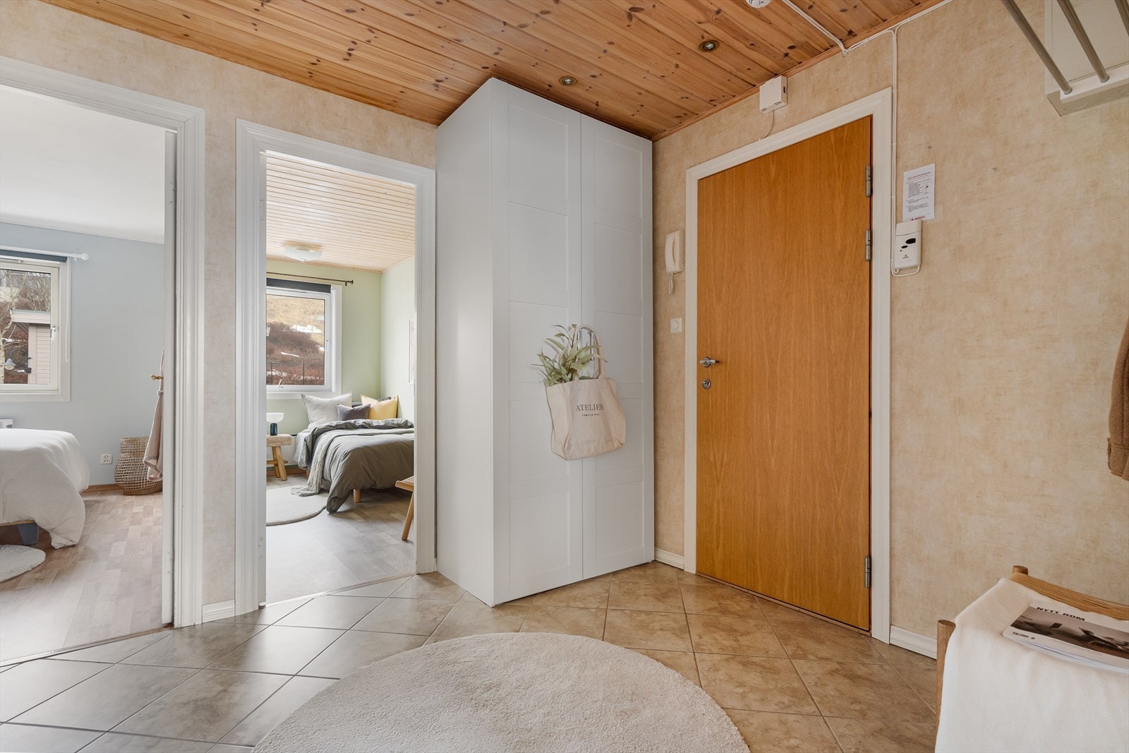 Romslig inngangsparti med fliser på gulv og garderobeskap. Panel med downlights i tak. Galleribilde