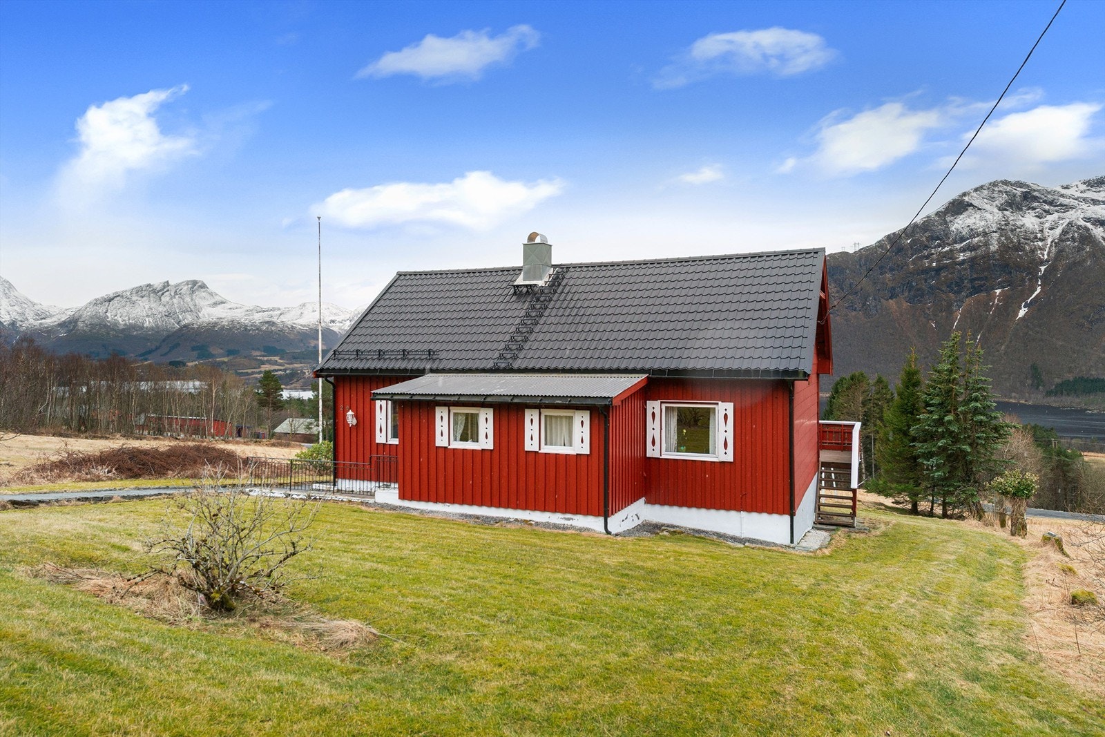 Boligen ligger på romslig tomt som er opparbeidet med plen og beplantning Galleribilde