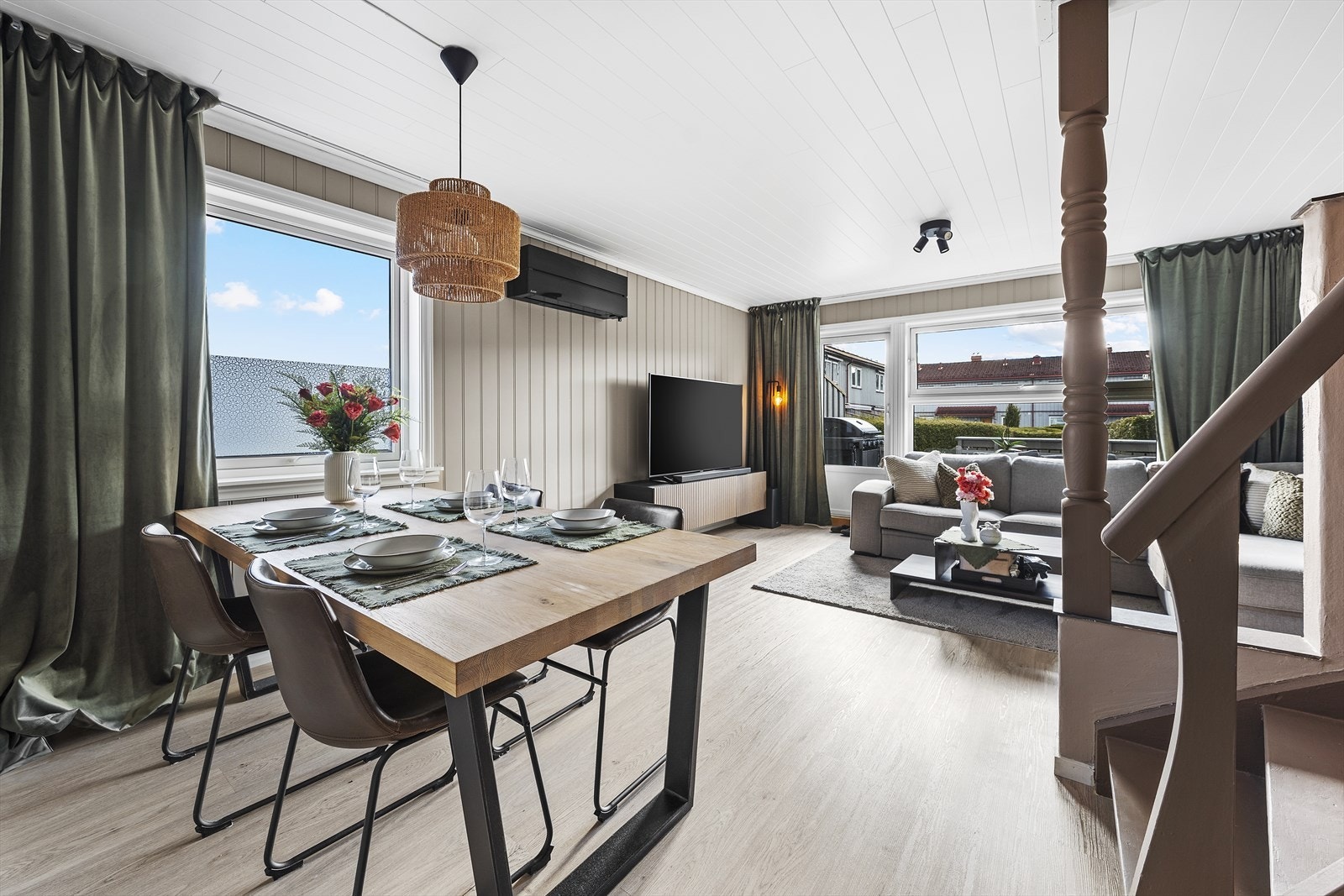 Lys og moderne stue med store vindusflater som slipper inn rikelig med dagslys Galleribilde