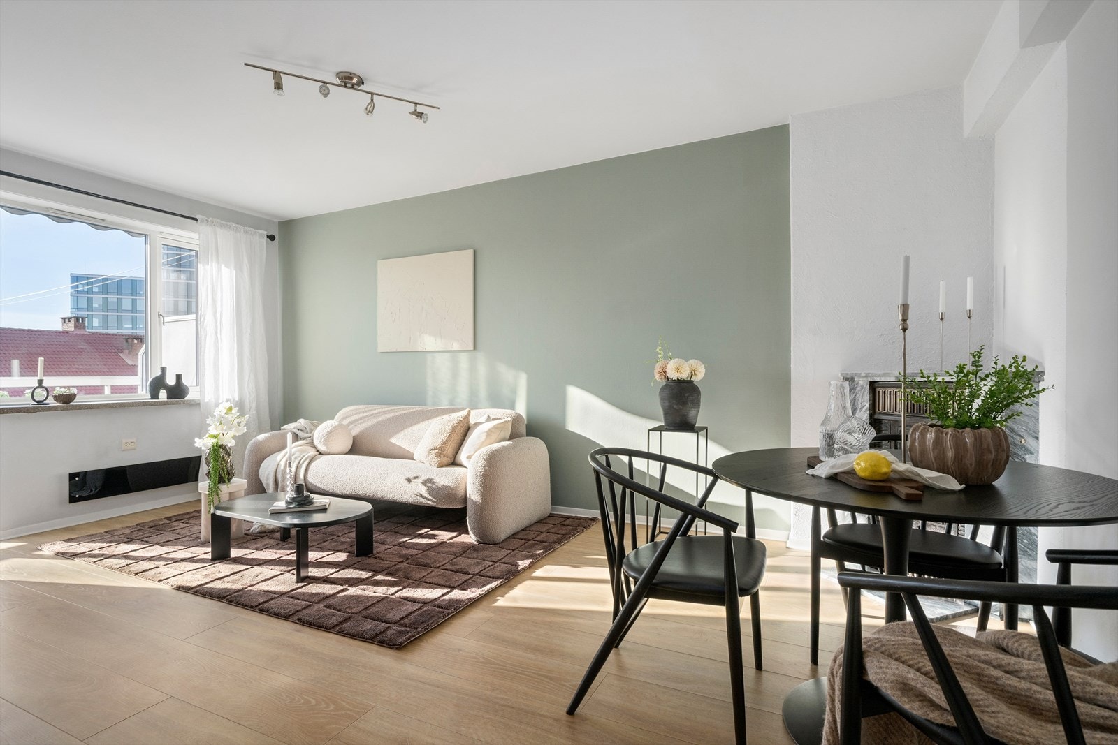 Stuen har laminatgulv, malte flater og en naturlig sone for både sofa og spisebord Galleribilde