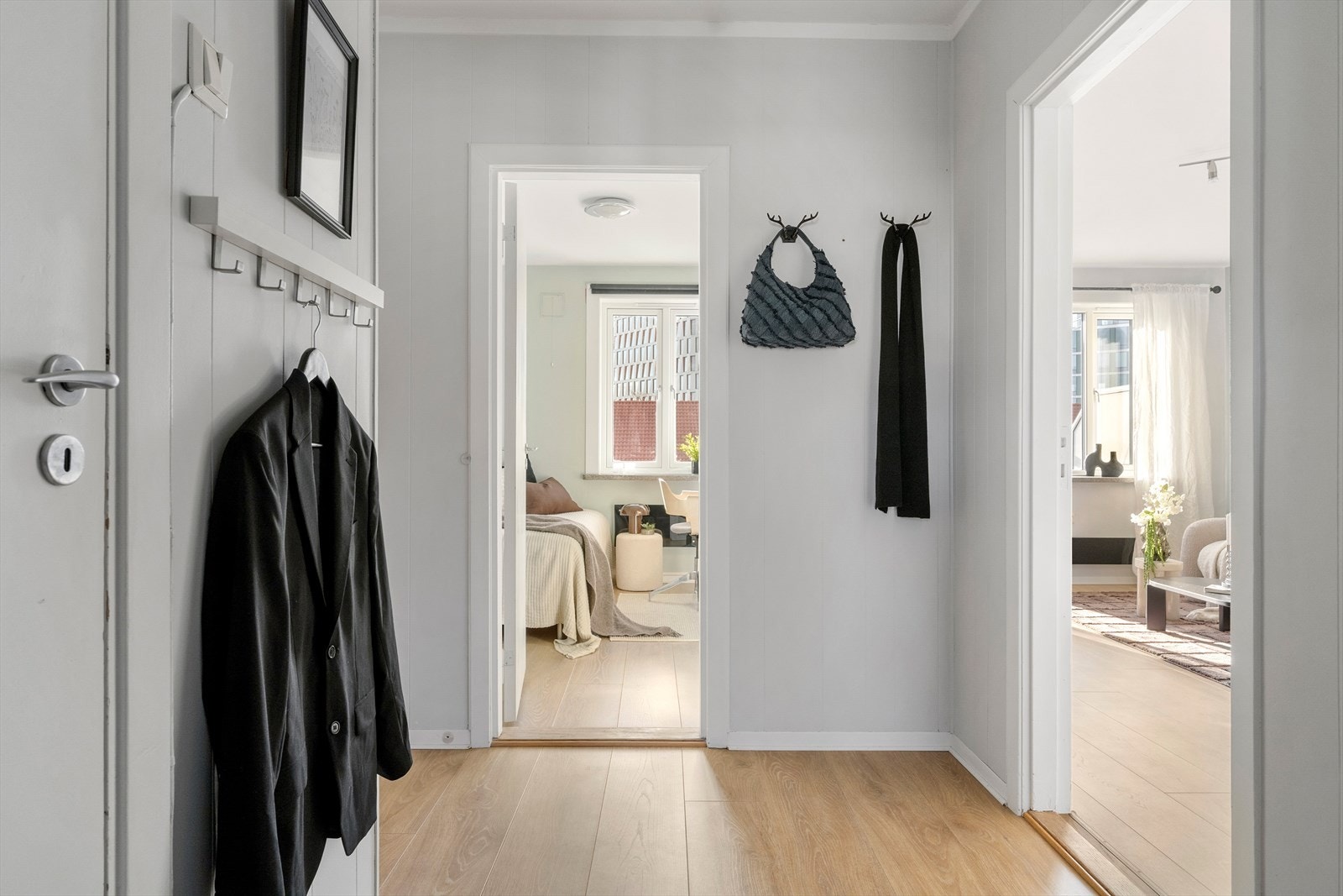 Hall med laminatgulv og åpen forbindelse videre til boligens oppholdsrom Galleribilde