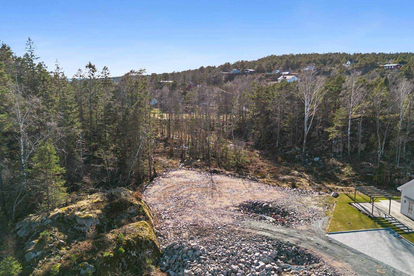 Tomten ligger tilbaketrukket med skogen som nærmeste nabo i bakkant Galleribilde