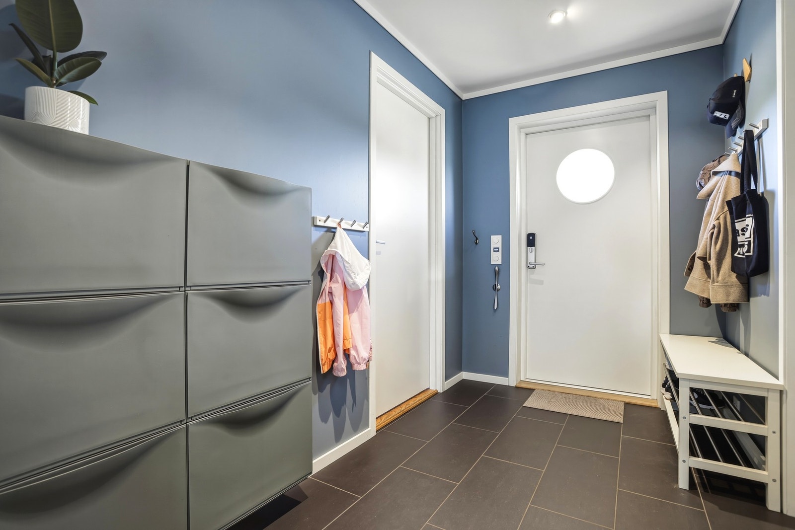 Vel inne blir man ønsket velkommen i en innbydende entré med glatte vegger og flislagt gulv med varmekabel. Galleribilde